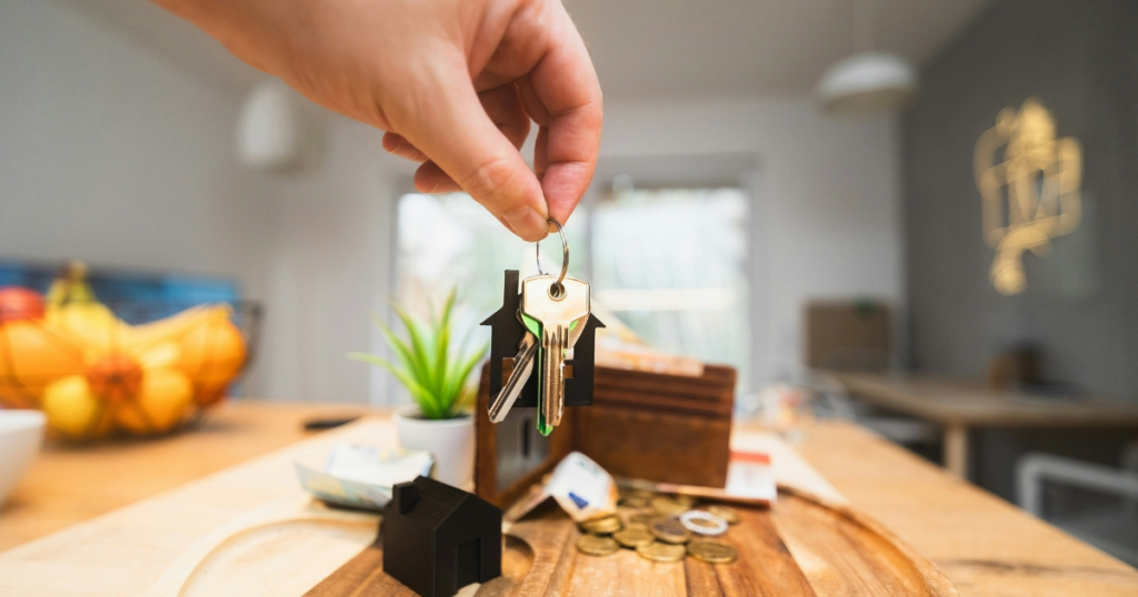 House keys held above a model.
