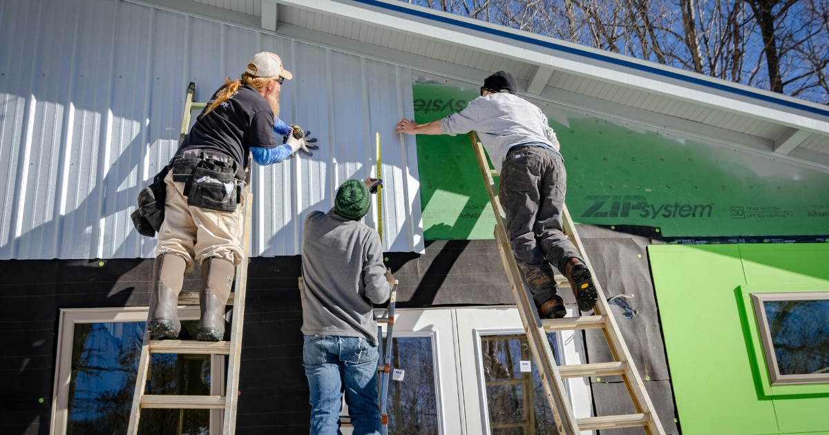 Workers installing exterior wall panels