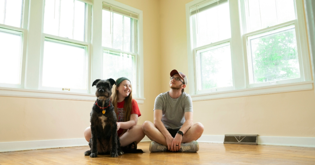 Young couple with dog in empty room